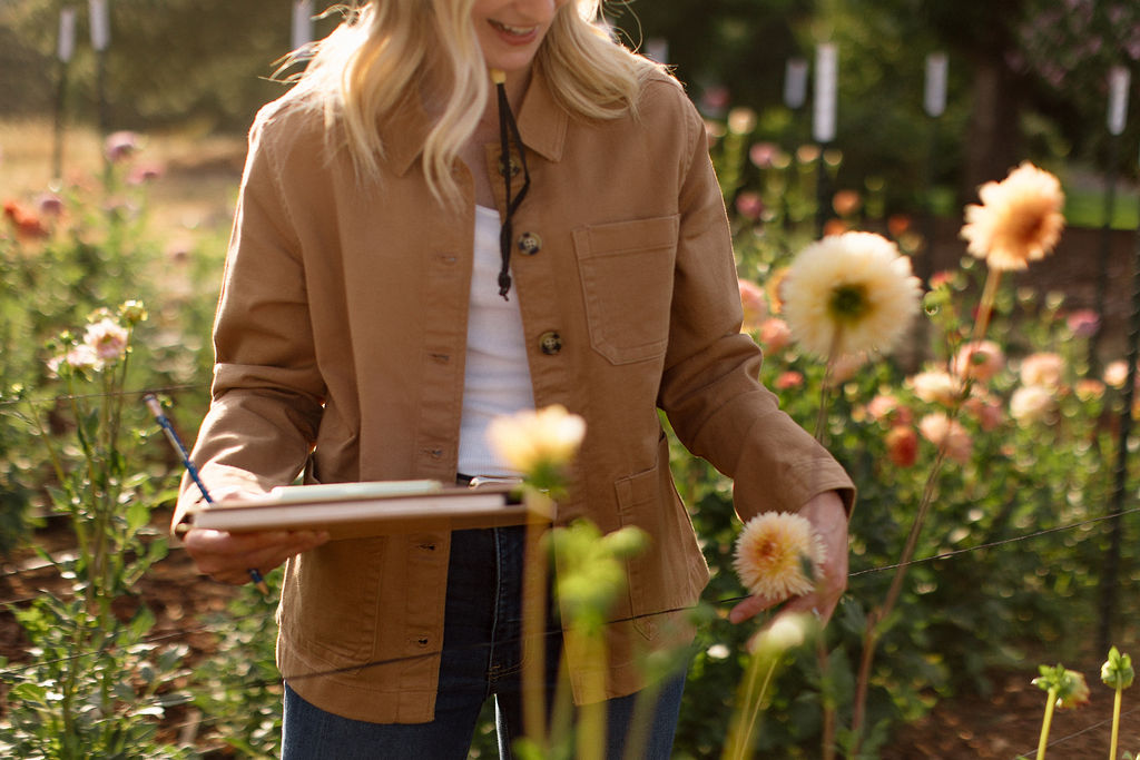 Christine taking notes among the dahlias in the garden