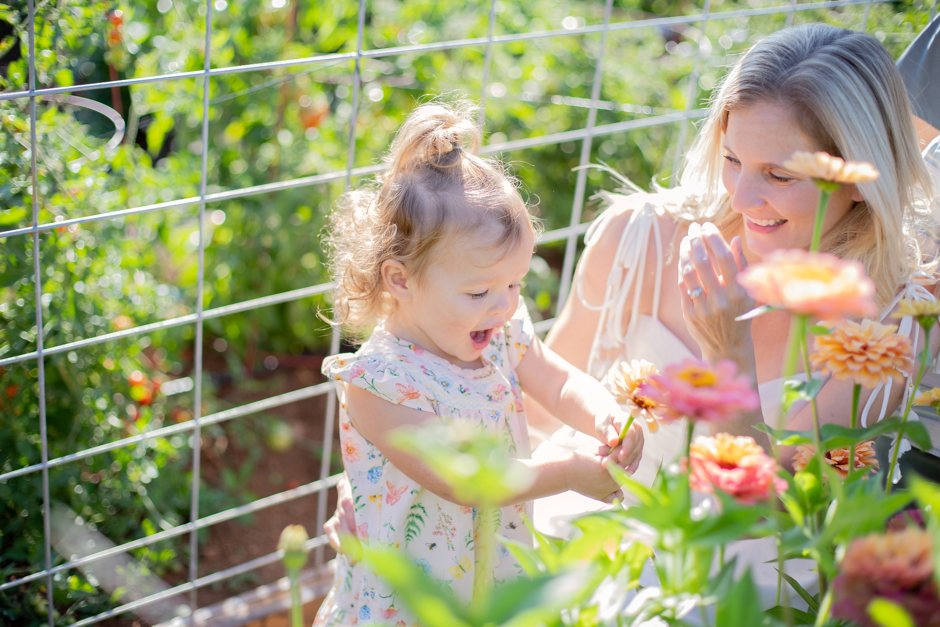 Christine and her daughter discovering a zinnia bloom